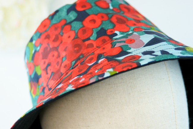 Détail du chapeau de pluie Ernest en coton enduit à fleurs rouge et vert