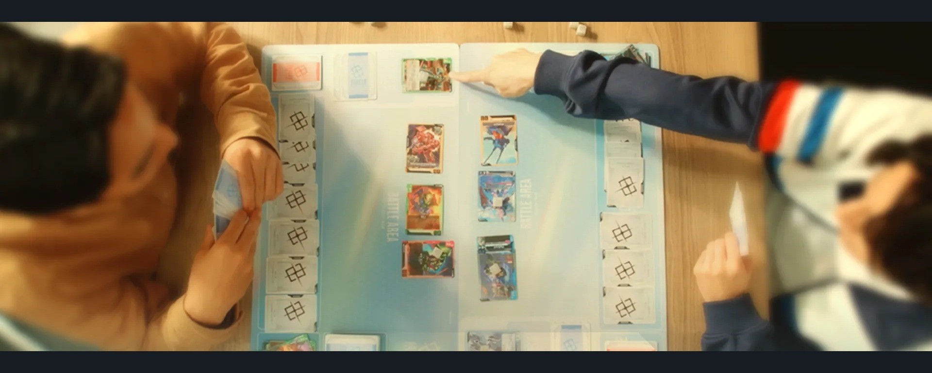 Joueurs et cartes du Gundam Card Game autour d’un tapis de jeu