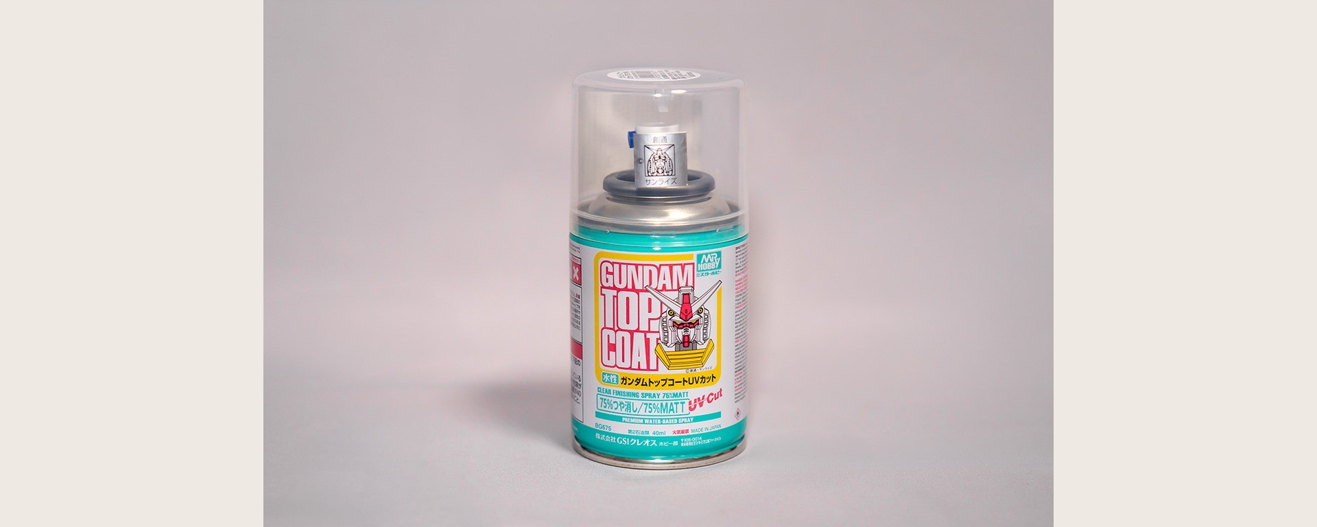 Aérosol Mr.Hobby Gundam Top Coat UV Cut mat, sur la couverture du guide Gunpla