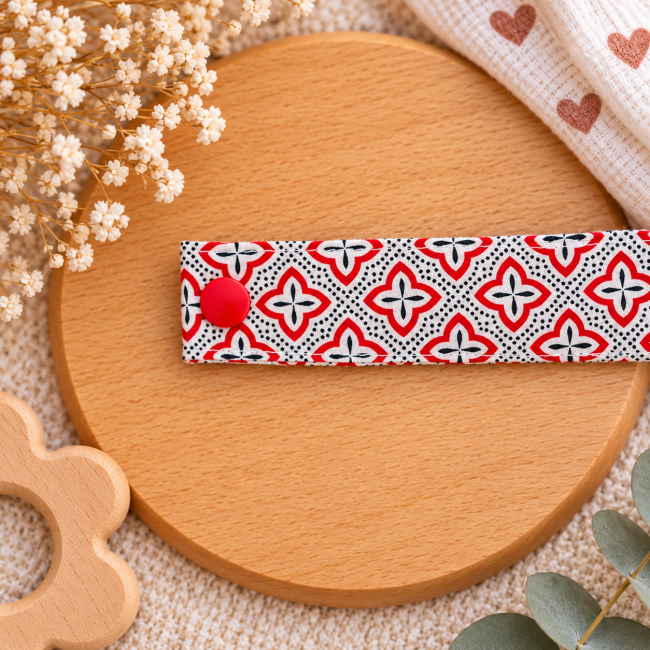 Pression rouge sur attache sucette en tissu à motifs géométriques