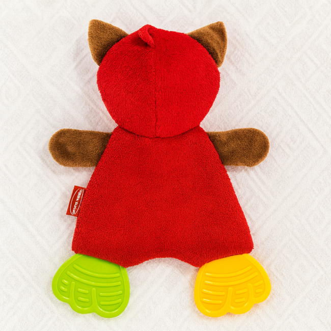 Jouet renard Infantino posé sur tissu blanc – seconde main lavé, pieds de dentition