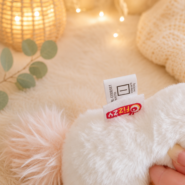 Peluche licorne blanche avec étiquette de composition et entretien
