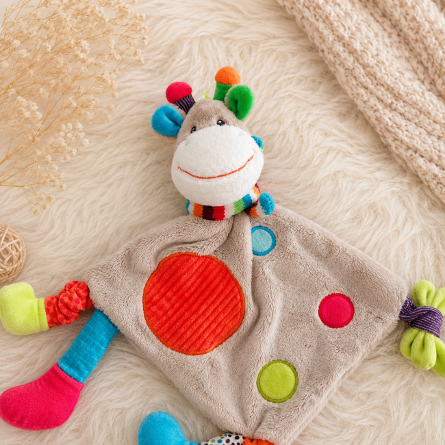 Gros plan sur le visage du doudou girafe multicolore bébé