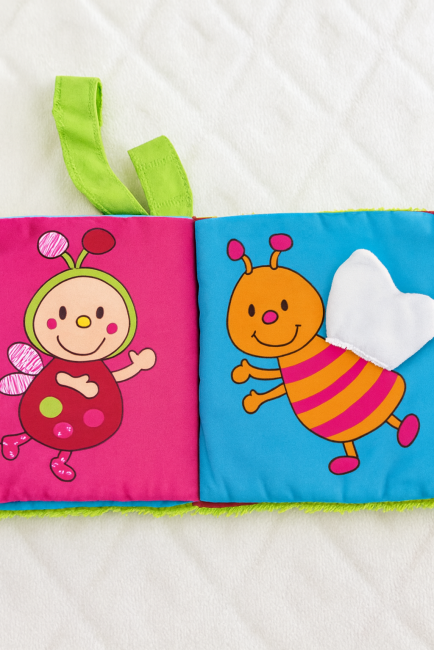 Livre en tissu pour enfant avec personnages brodés et bandeau 