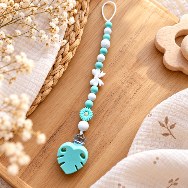 Attache sucette artisanale en perles silicone vert et blanc avec fleur et embout feuille.