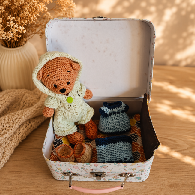 Doudou ours au crochet portant une combinaison à capuche vert anis