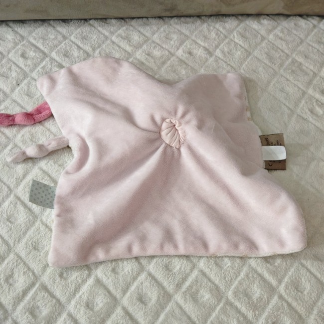 Doudou rose en bon état avec nœuds torsadés et étiquettes