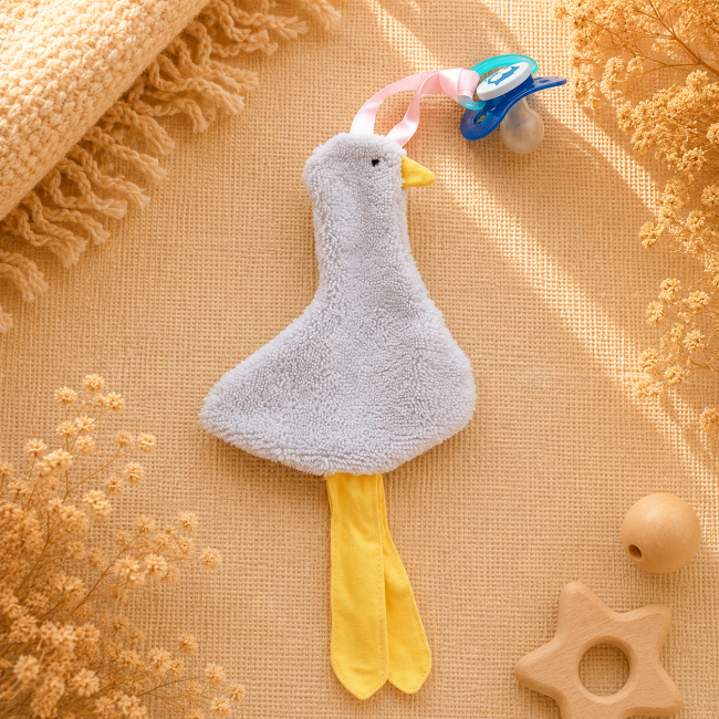 Attache-sucette artisanal canard gris clair avec pattes jaunes et ruban rose