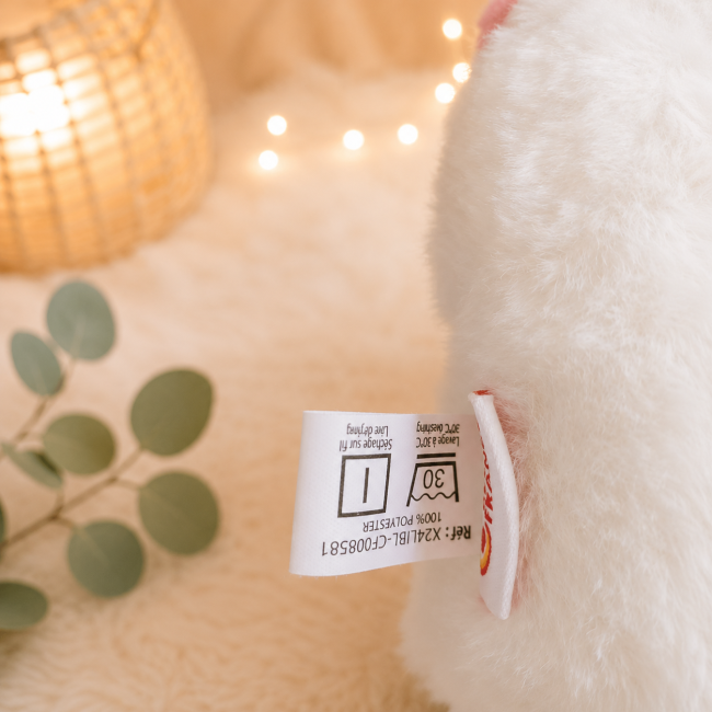 Peluche licorne blanche avec étiquette de composition, entretien et marque
