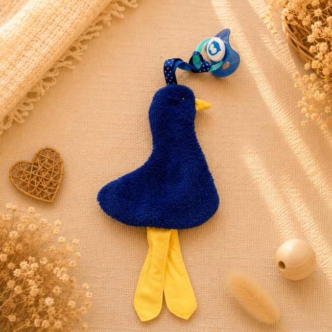 Attache-sucette artisanal canard bleu marine avec pattes jaunes et ruban à pois