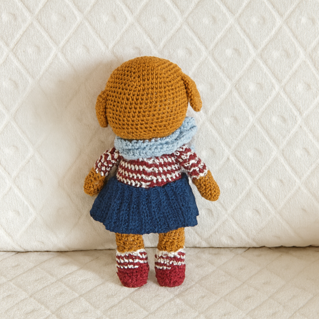 Dos du doudou chien crocheté avec vêtements amovibles sur fond blanc à motif losange