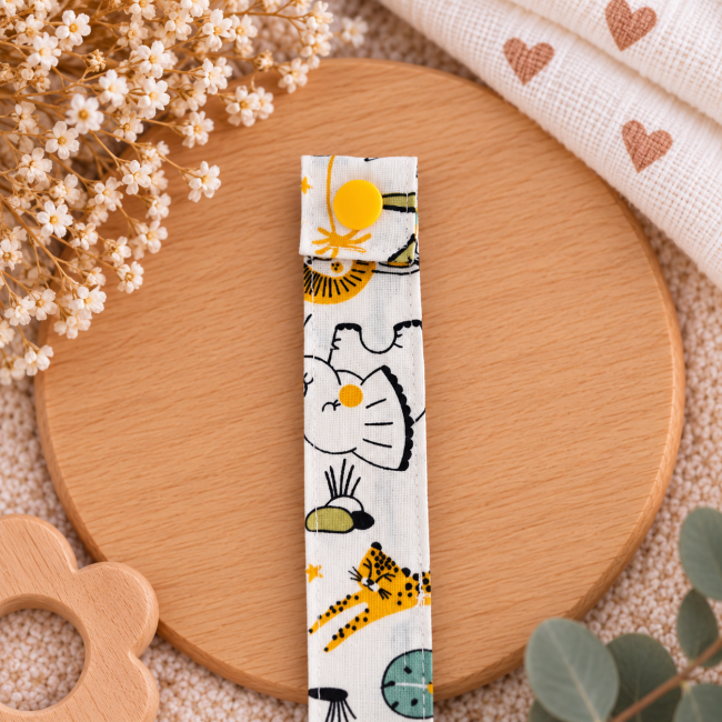 Tissu écru à motifs animaux turquoise jaune et orange de l'attache sucette