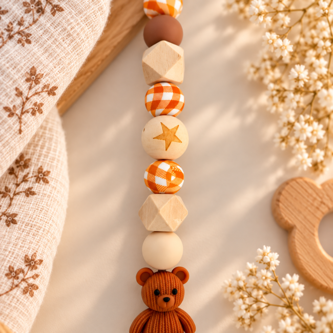 Détail des perles silicone orange vichy et bois naturel avec étoile gravée