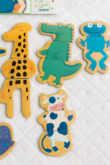 Pièces de puzzle animaux Djeco en bois aimanté, combinées de façon ludique sur fond matelassé