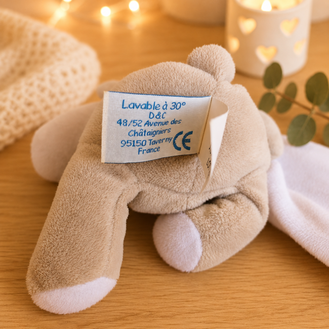 Doudou beige – Étiquette entretien et marquage CE Étiquette entretien du doudou beige avec lavage à 30 degrés et marquage CE