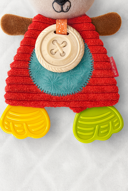  Gros plan sur jouet sensoriel Infantino – bouton texturé, tissus colorés et ruban orange