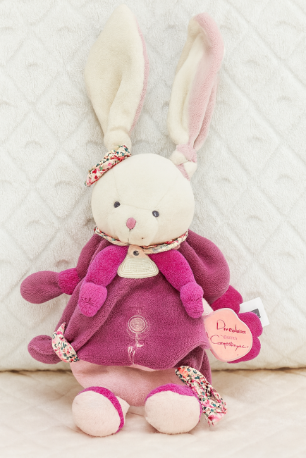  Lapin en peluche Doudou et Compagnie assis, cape violette et écharpe rose, nœuds fleuris