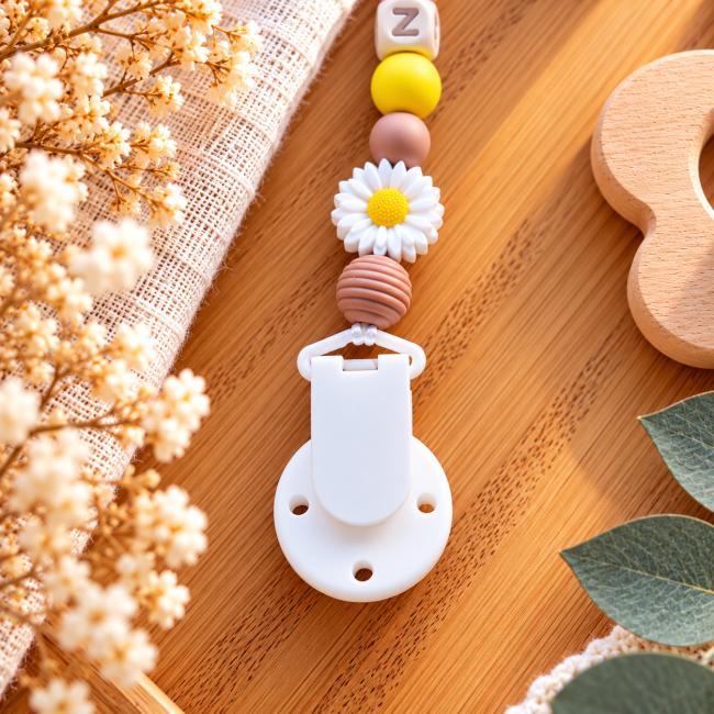 Dos de l’attache sucette avec pince blanche à trois trous, perles silicone marron et jaune et marguerite décorative