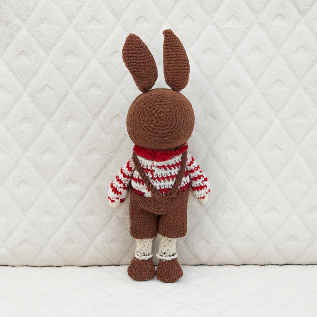 Dos du doudou lapin crocheté, salopette marron et pull rayé rouge et blanc