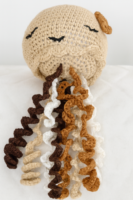 Méduse en crochet beige avec tentacules bouclées multicolores, jouet artisanal pour enfant