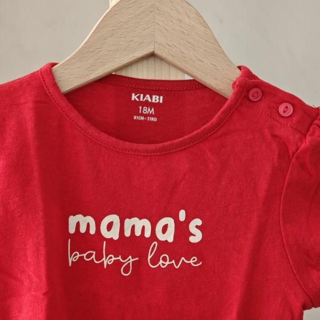 T-shirt bébé rouge 18 mois – vue avant détaillée T-shirt bébé rouge « mama's baby love » avec étiquette KIABI 18 mois visible, suspendu sur cintre.