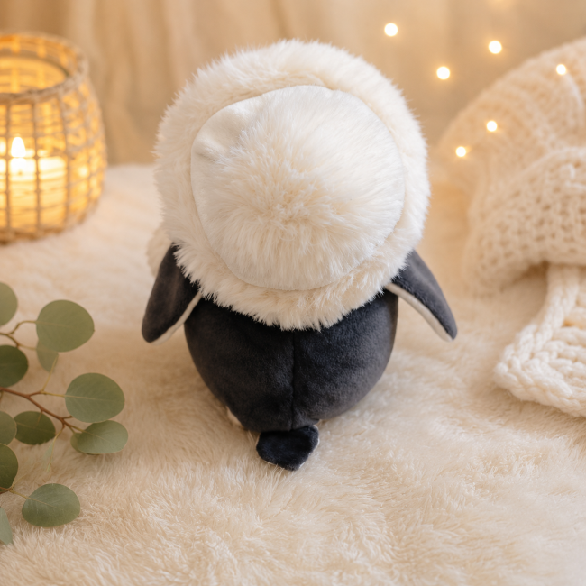 Pingouin en peluche noir et blanc avec bonnet vu de dos