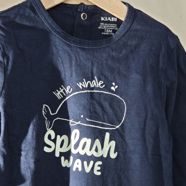 Pyjama bleu marine bébé 18 mois avec baleine et texte Little Whale Splash Wave, présenté sur cintre.