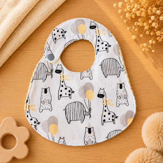 ad3db757-cc85-4d66-b8ea-965657a410d0 Bavoir artisanal bébé T2 en coton imprimé animaux jaune beige gris et noir
