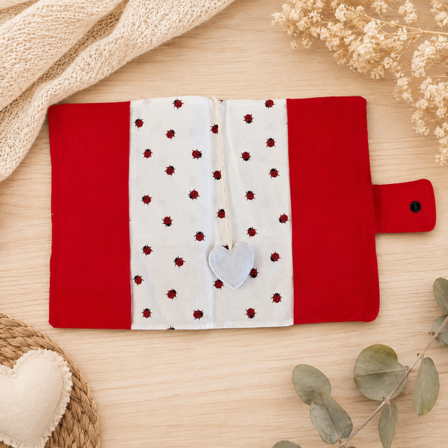 Protège-carnet de santé bébé ouvert avec marque-page cœur en feutrine