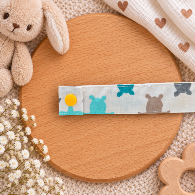 Détail du tissu écru à motifs de tortues turquoise et jaunes