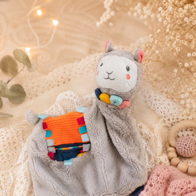 Gros plan sur le visage du doudou lama sensoriel bébé