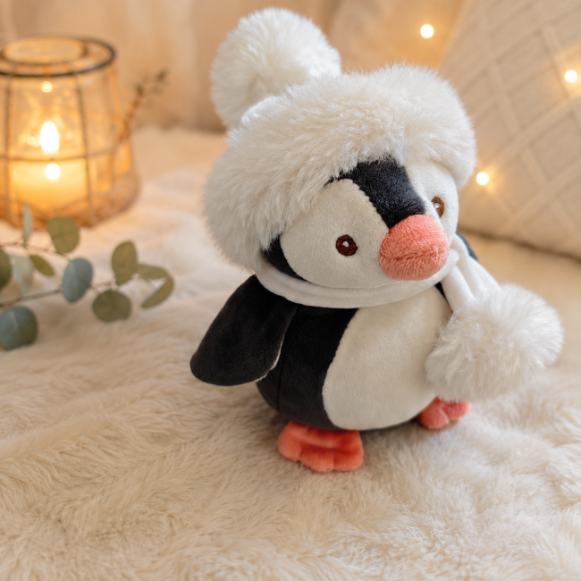 Pingouin en peluche avec bonnet blanc et écharpe vu de profil