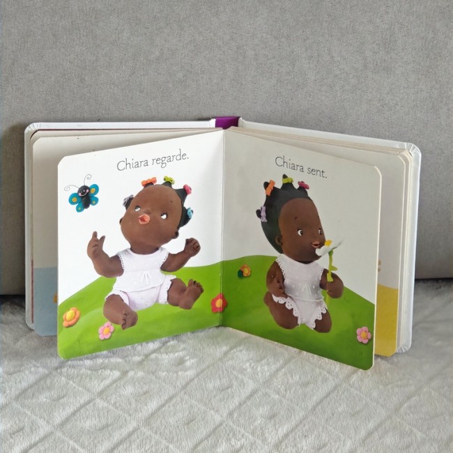 Double page — Chiara regarde et sent Double page illustrée : Chiara regarde un papillon et sent une fleur; textes courts pour apprentissage.