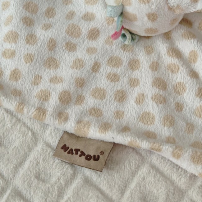 Étiquette NATTOU sur doudou girafe, détail marque