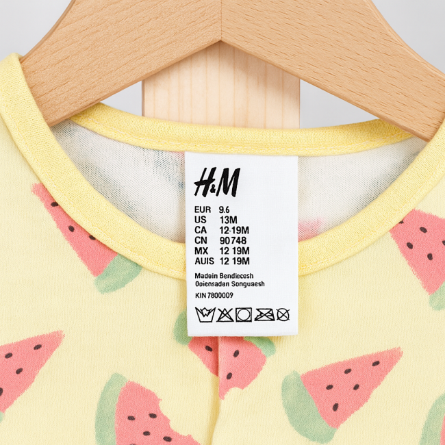 Étiquette H&M du body bébé fille indiquant la taille 12-18 mois et le pays de fabrication