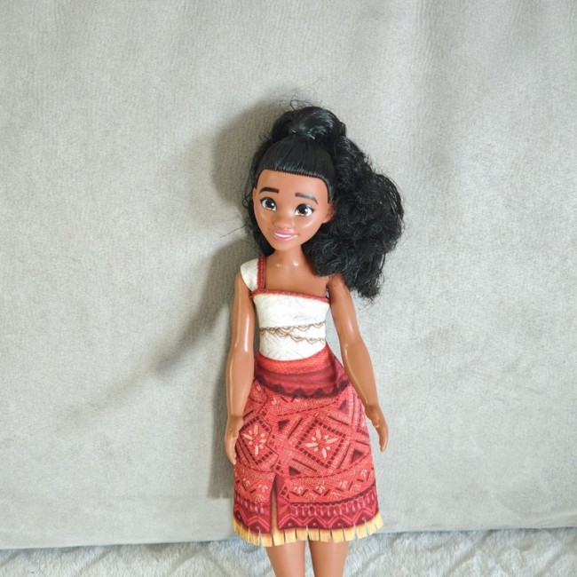 Poupée d’inspiration polynésienne avec cheveux bouclés et haut blanc, gros plan