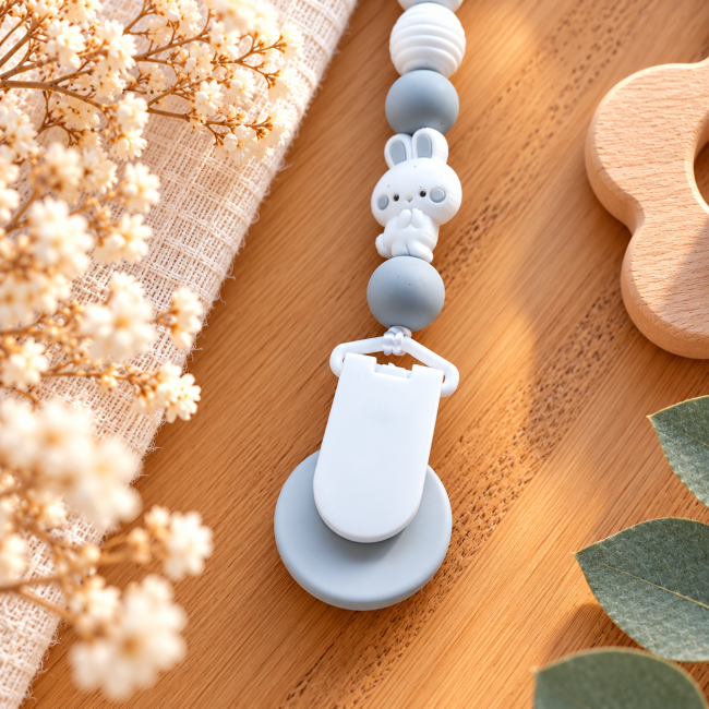 Dos de l’attache sucette et pince blanche Dos de l’attache sucette avec pince blanche ronde et perles silicone grises et blanches