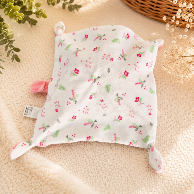 Doudou rose en bon état avec nœuds torsadés et étiquettes