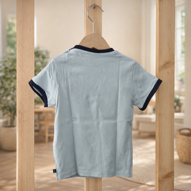 Tee-shirt OBAÏBI 18 mois présenté en ambiance chaleureuse Tee-shirt OBAÏBI bleu clair 18 mois présenté dans une ambiance douce