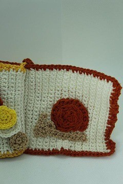 Page de livre crocheté avec escargot rouge et fond blanc