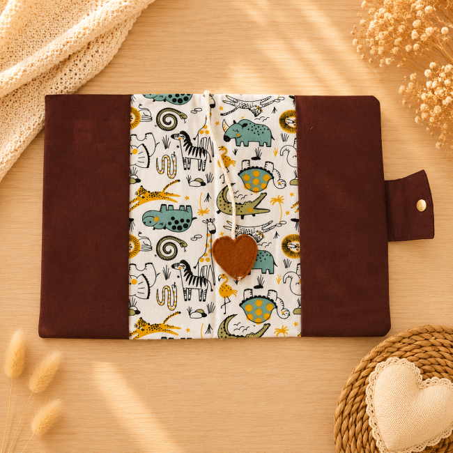 Protège-carnet de santé bébé ouvert avec tissu animaux de la savane et cœur en feutrine