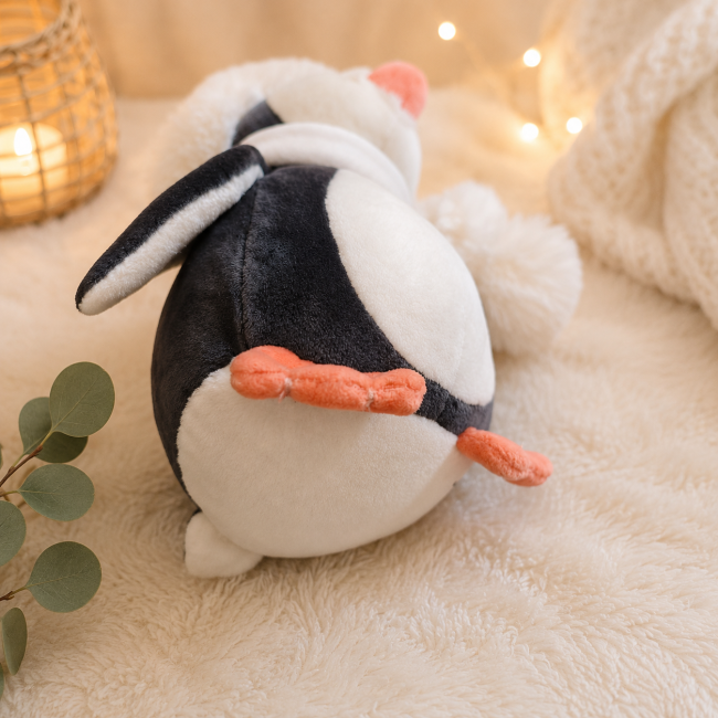 Pingouin en peluche vu de dessous avec ses pattes orange