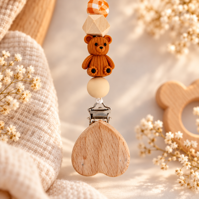 Gros plan sur l’ourson caramel et la pince en bois naturel de l’attache-sucette