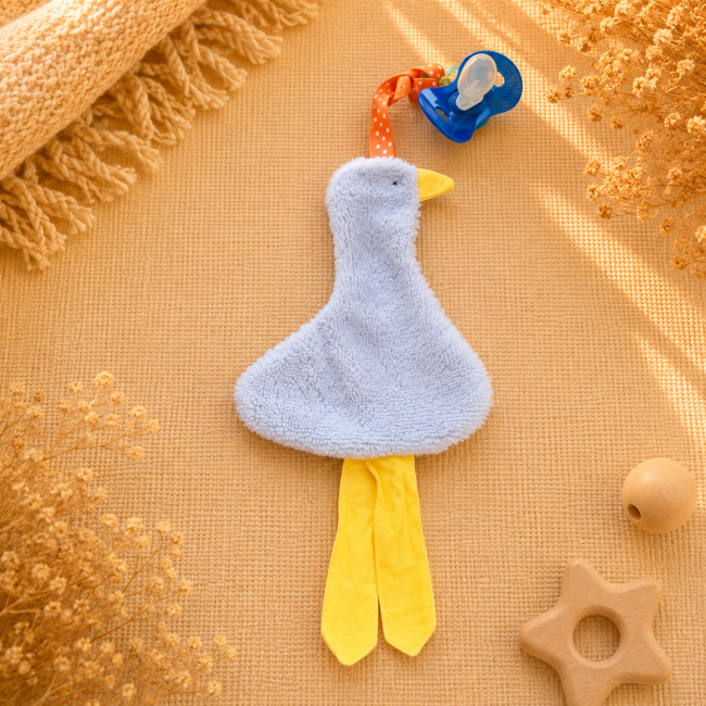 Attache-sucette artisanal canard gris clair avec pattes jaunes et ruban orange