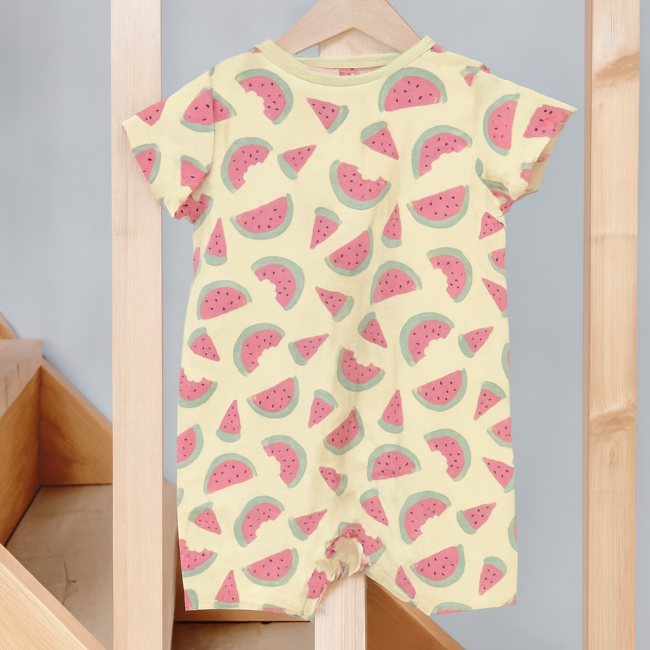 Body bébé fille jaune à motifs pastèque suspendu sur cintre en bois dans décor naturel vue de dos