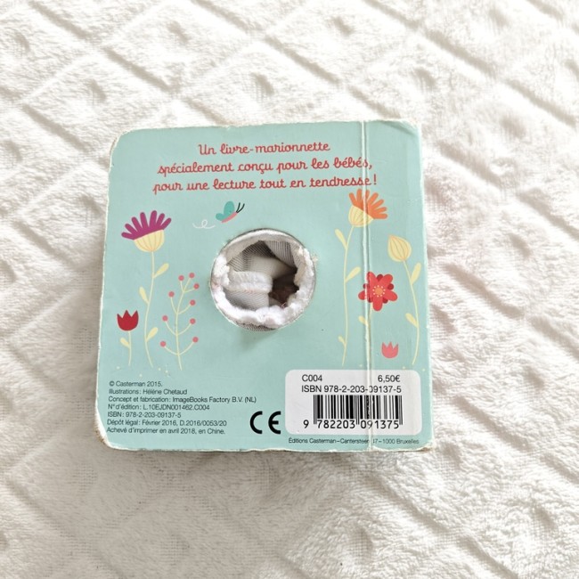 Quatrième de couverture et mentions d’édition Quatrième de couverture bleu avec trou laissant apparaître la marionnette, mentions d’édition et code-barres.