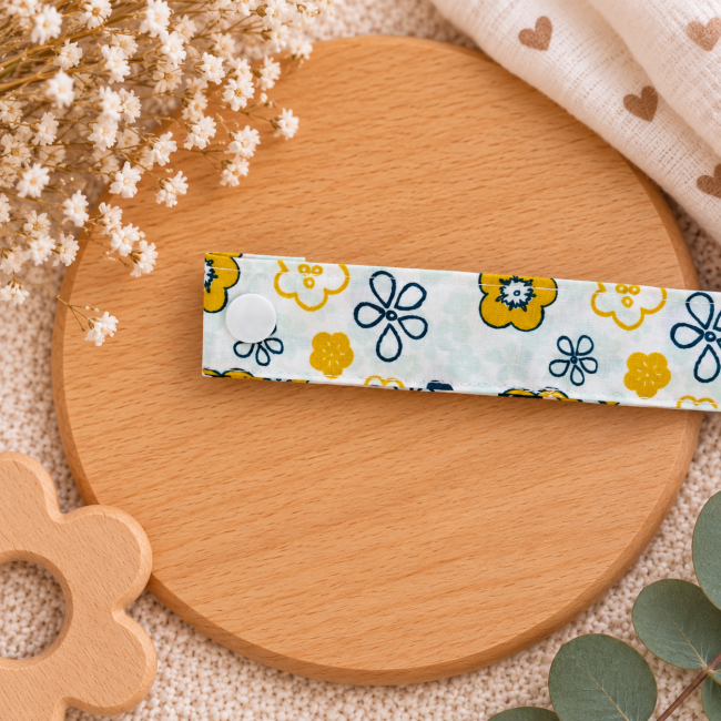 Pression blanche sur attache sucette en tissu fleuri jaune et bleu