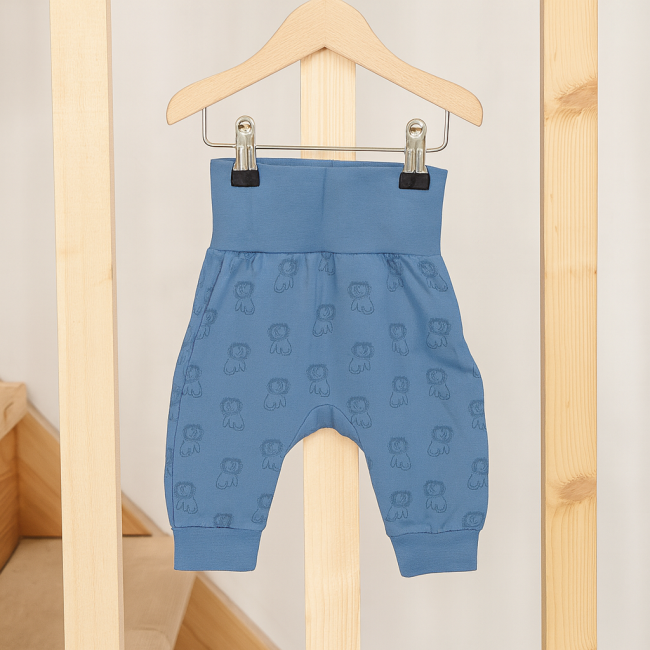Détail du pantalon bébé bleu à motifs lions avec taille haute et revers aux chevilles