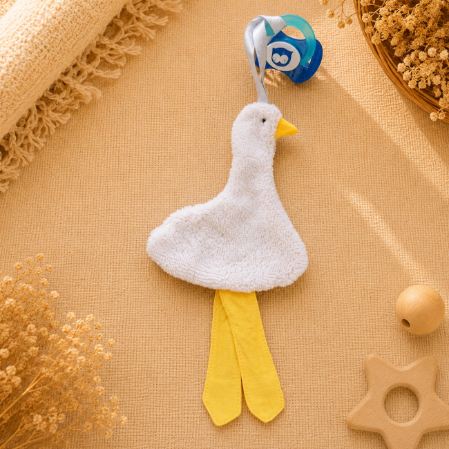 Attache-sucette artisanal canard gris clair avec pattes jaunes et ruban blanc bleu