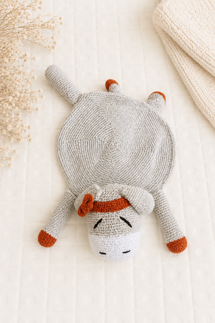 Doudou artisanal au crochet gris dans une ambiance douce et naturelle